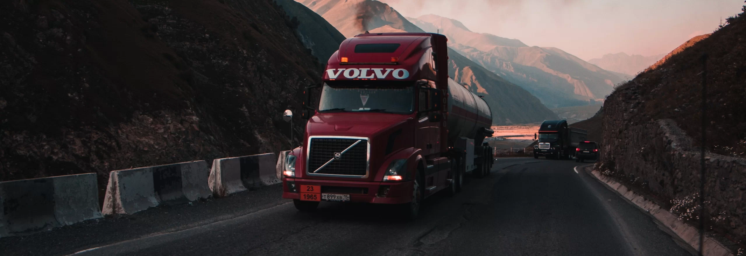 A temperature-controlled semi truck driving down a mountain road.